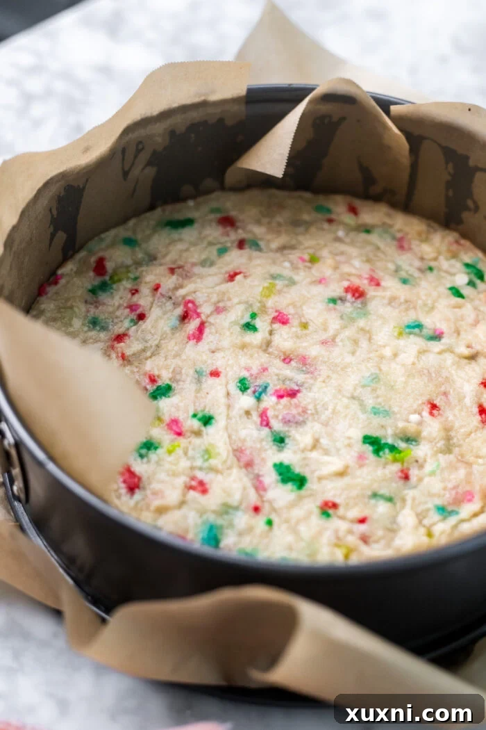 Vegan shortbread crust pressed into a springform pan, ready for baking.