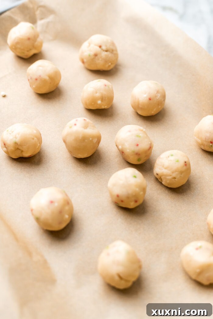 Edible vegan sugar cookie dough formed into small balls, ready for chilling.