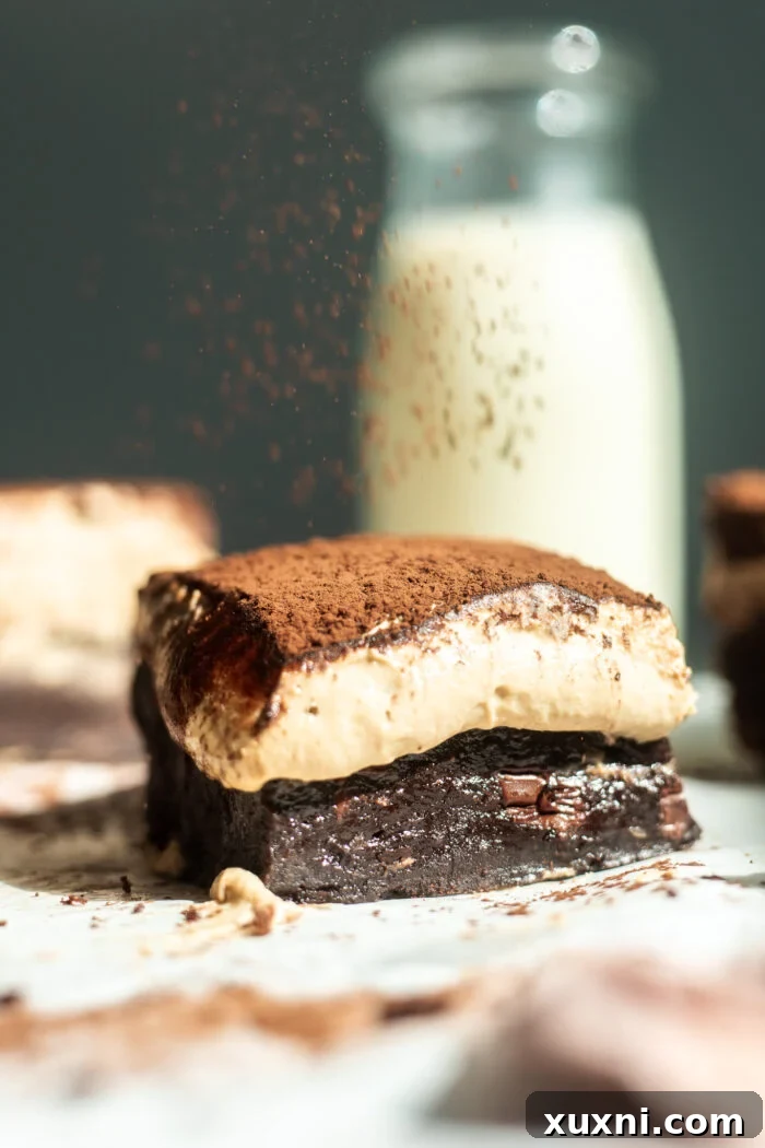 dusting cocoa on tiramisu brownie