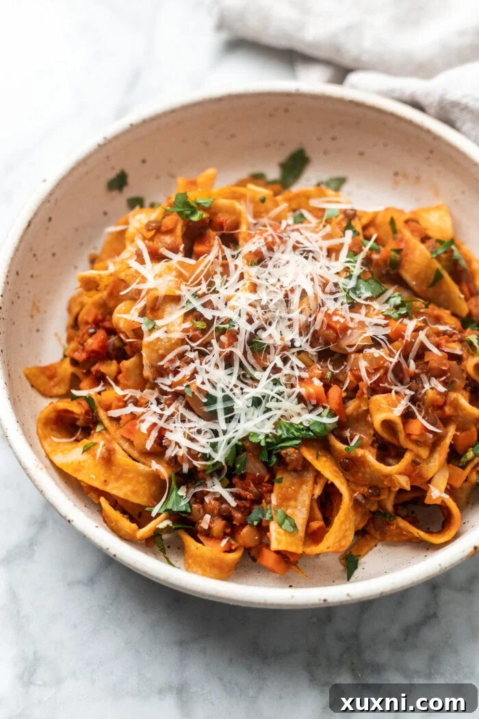 The Easiest 8-Ingredient Plant-Based Bolognese 9 A beautifully styled bowl of lentil bolognese pasta, with a rustic kitchen cloth nearby, inviting you to dig in.