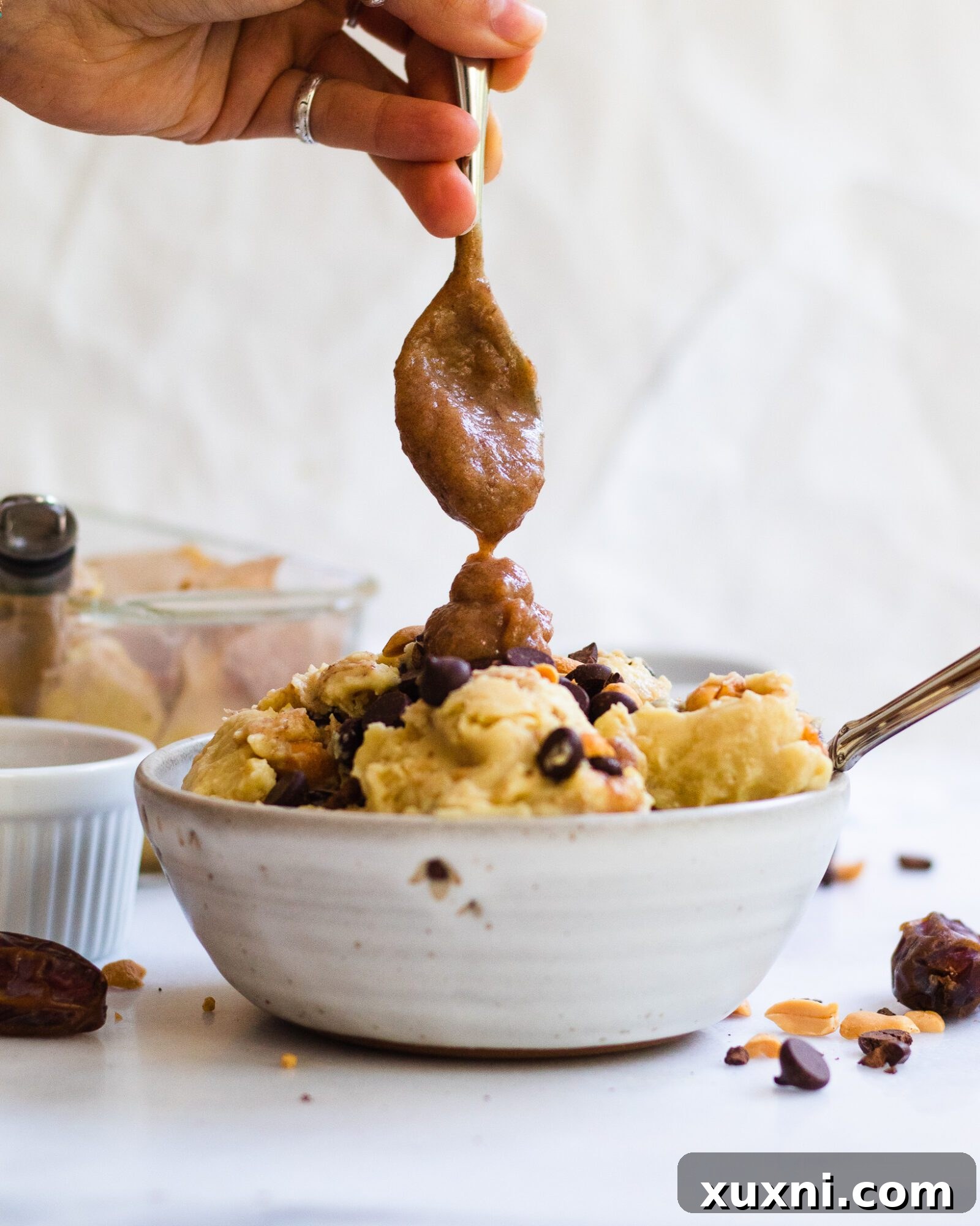 spoon pouring date caramel onto the ice cream