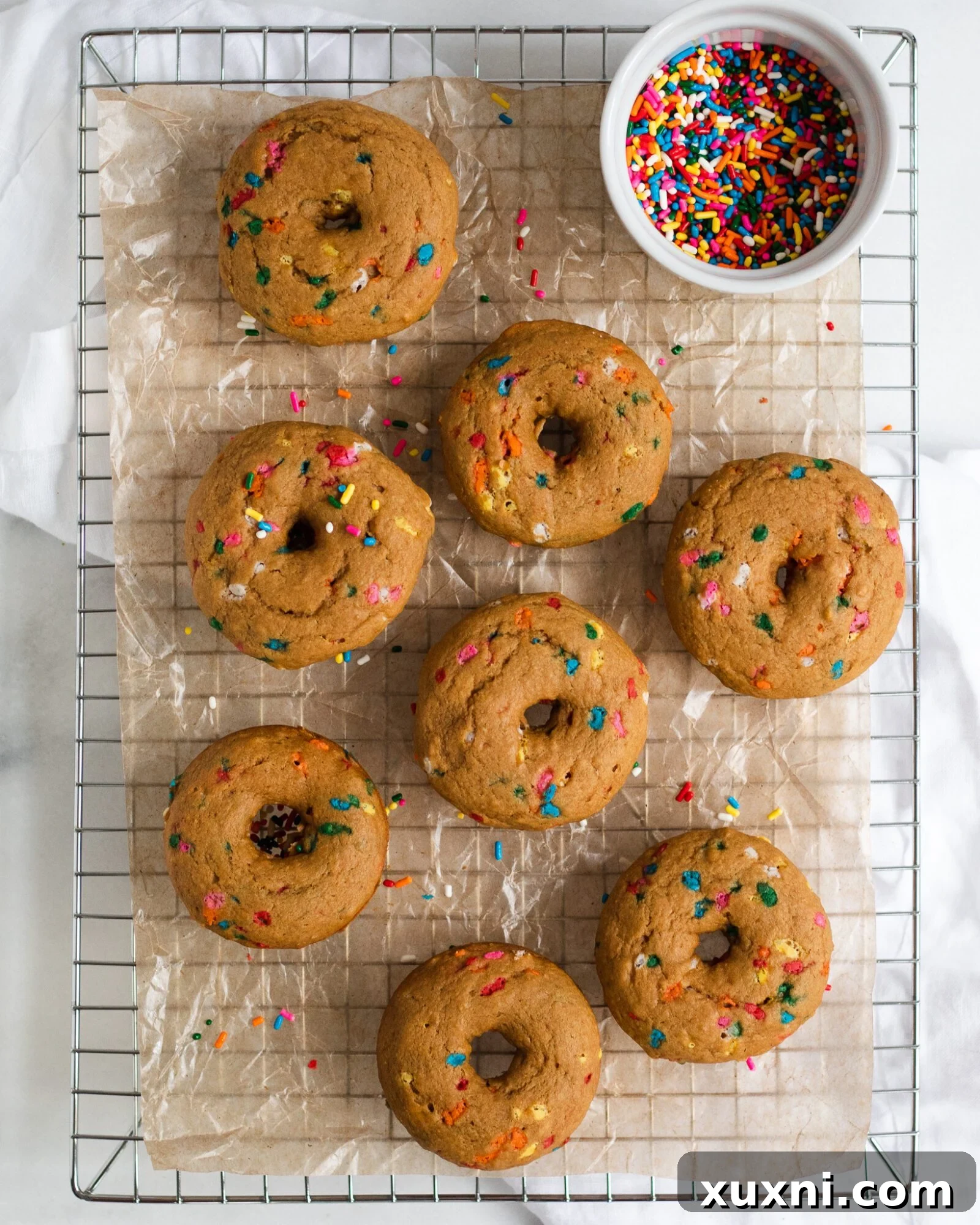 Vegan Birthday Donut Delights 16 vegan birthday cake donuts on a cool rack with sprinkles