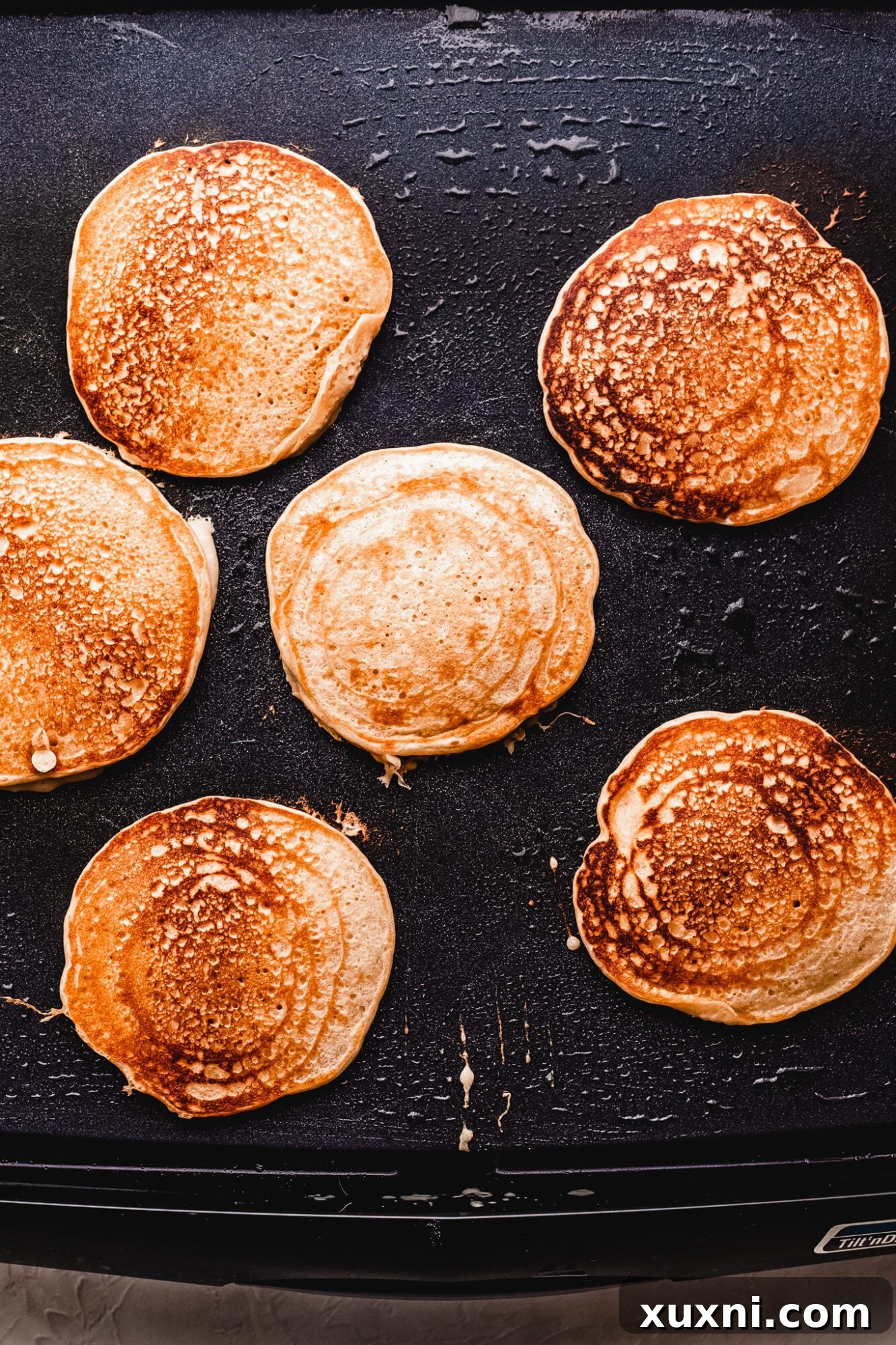 Close-up of fluffy vegan pancakes sizzling on a hot griddle