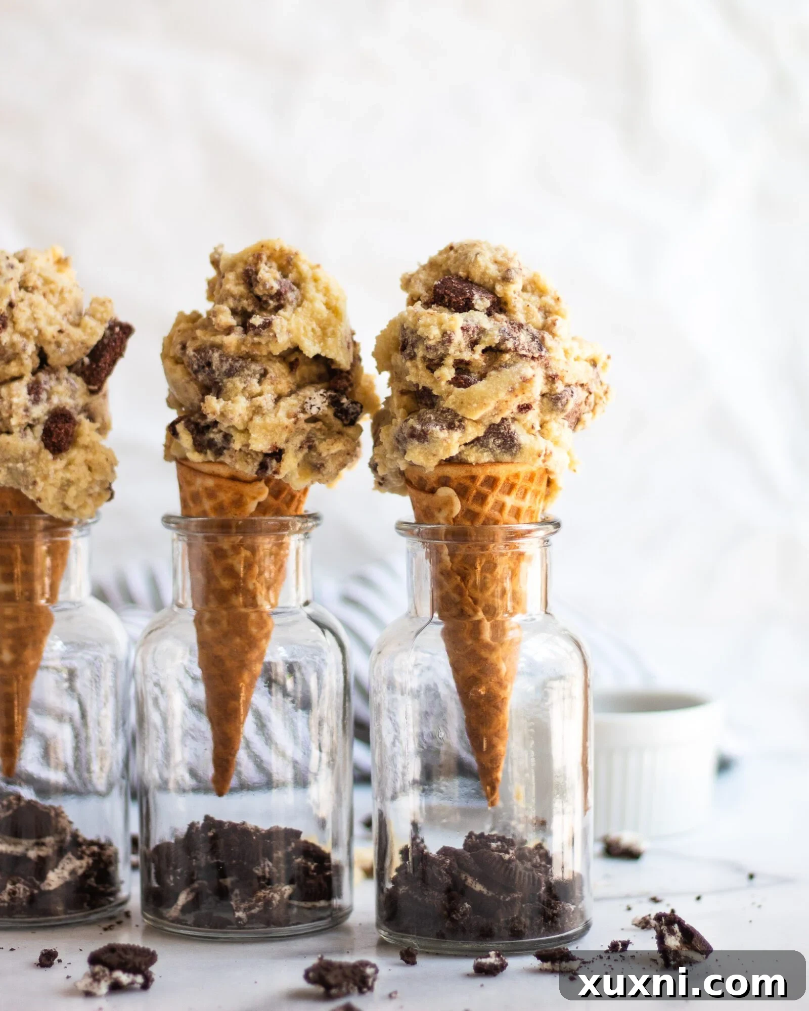 three ice cream cones stacked with cookies and cream ice cream