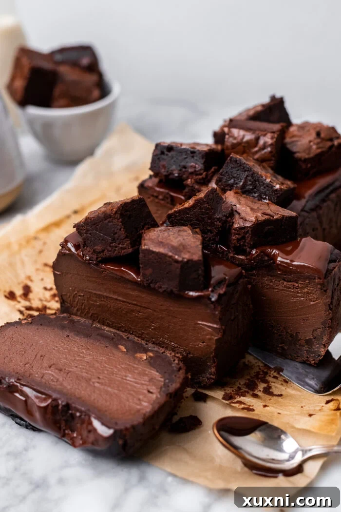 A perfectly sliced vegan brownie Basque cheesecake revealing its fudgy brownie base and creamy chocolate top, garnished beautifully.