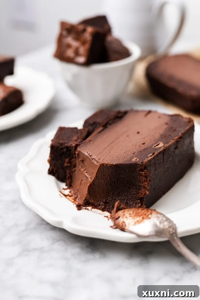 A close-up of a bitten slice of vegan brownie Basque cheesecake, showing its rich texture.