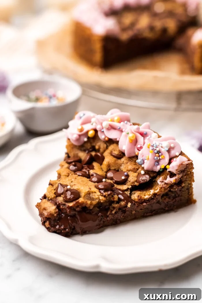 A perfectly portioned slice of vegan Nutella-stuffed cookie cake on a white plate, showing the golden-brown crust and gooey filling.