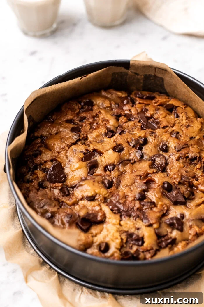 Image depicting the top layer of cookie dough being placed over the Nutella filling, ready for baking.