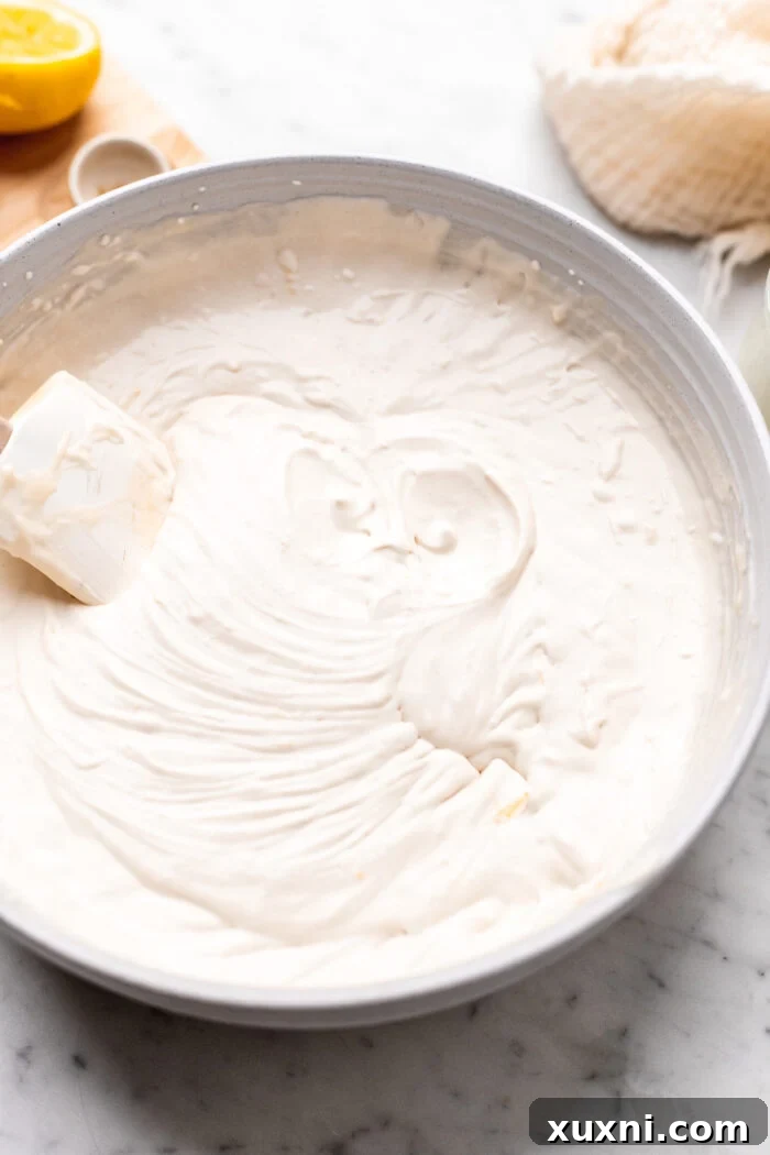 Vegan heavy cream being whipped to soft peaks in a chilled bowl.