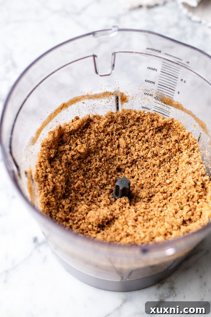 Crushed waffle cone crumbs prepared in a food processor, ready to be mixed for the choco taco cheesecake crust.
