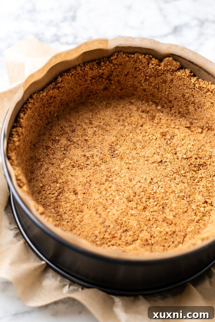 Choco taco cheesecake crust, a blend of waffle cone crumbs and melted vegan butter, firmly pressed into a springform pan before freezing.