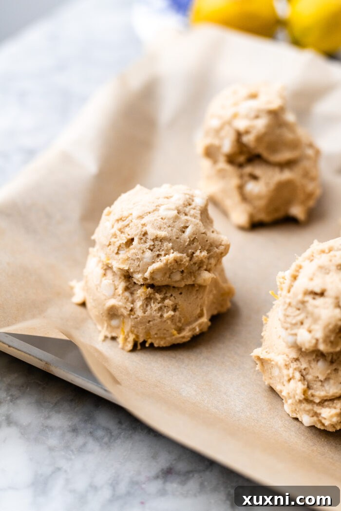 scooped tall mounds of vegan lemon cookie dough on parchment paper
