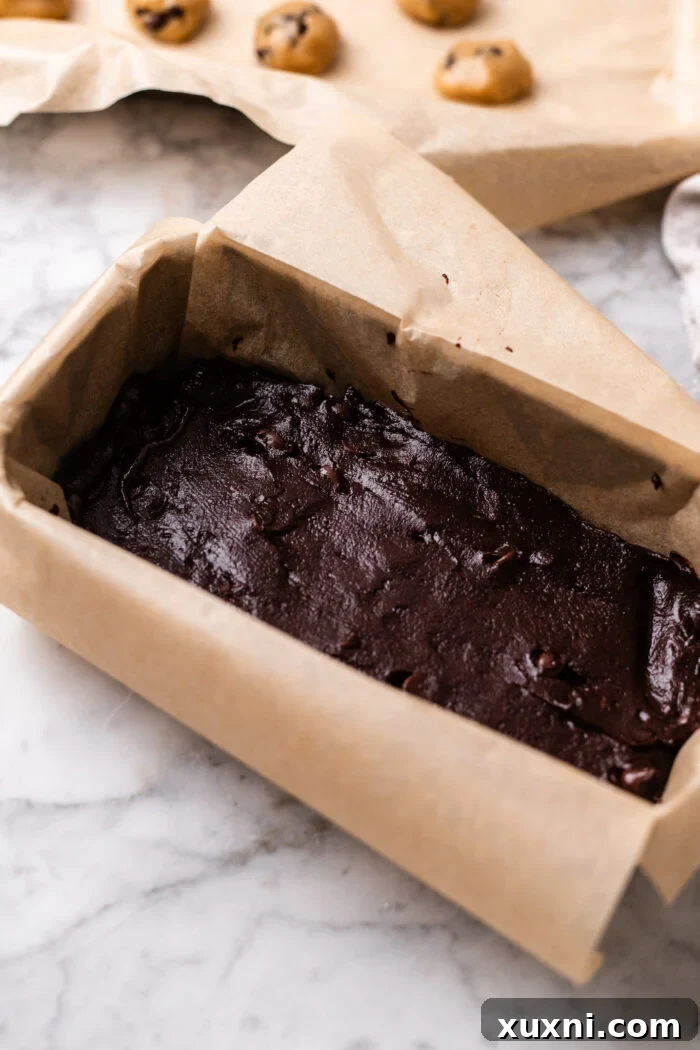 Plant-Powered Brookie Basque Cheesecake Bars for Small Cravings 7 Assembling the fudgy brownie batter into the prepared loaf pan for the cheesecake base.