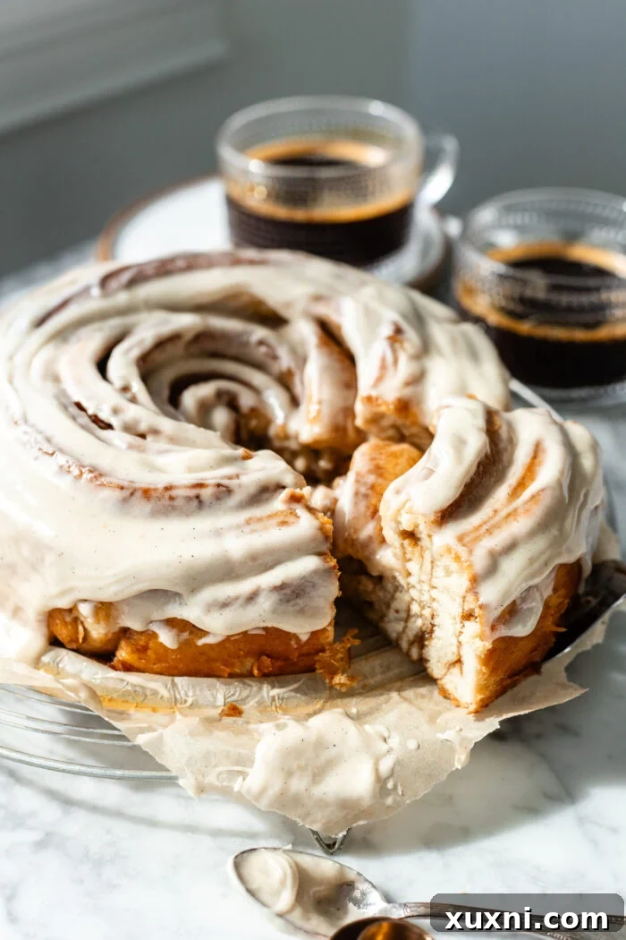 A beautiful slice of the vegan cinnamon roll cake, showing the rich, gooey layers and fluffy dough, ready to eat.
