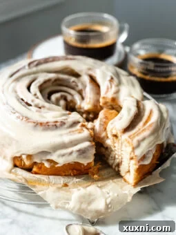 A delicious slice of vegan cinnamon roll cake on a plate, showing its rich, gooey texture and fluffy dough, ready to be enjoyed.