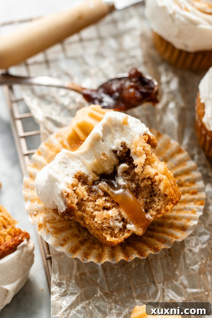 Close-up of a perfectly frosted vegan apple cider cupcake, showcasing its rich texture.