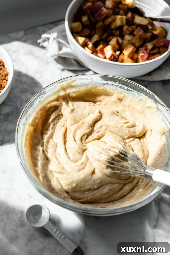 A bowl of smooth, pale brown butter vanilla cake batter, showcasing its consistent and creamy texture before the final assembly.