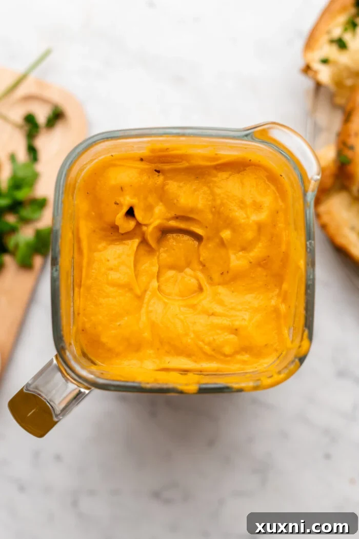 A perfectly smooth and creamy vegan butternut squash and sweet potato soup after being blended, ready to be heated and served.