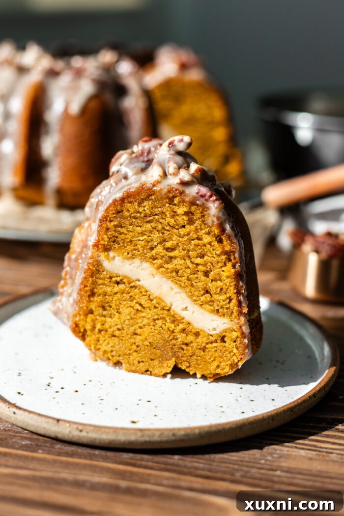 slice of pumpkin bundt cake on a plate with glaze