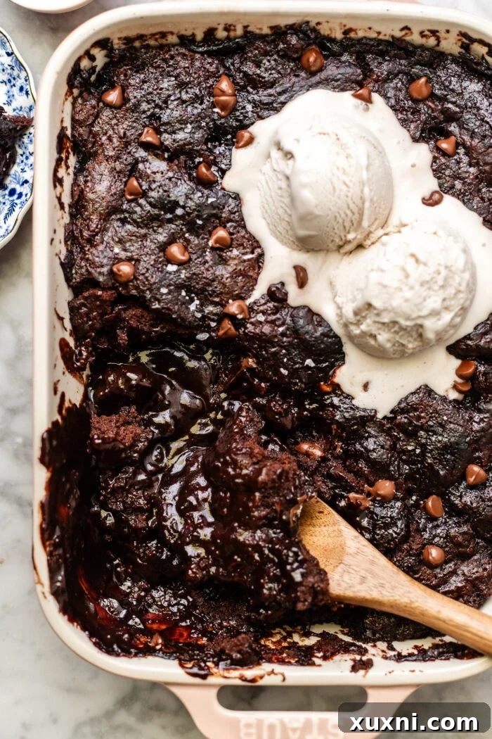 Close-up shot of a scooped portion of the self-saucing chocolate pudding cake, revealing the moist cake and abundant molten chocolate sauce underneath.