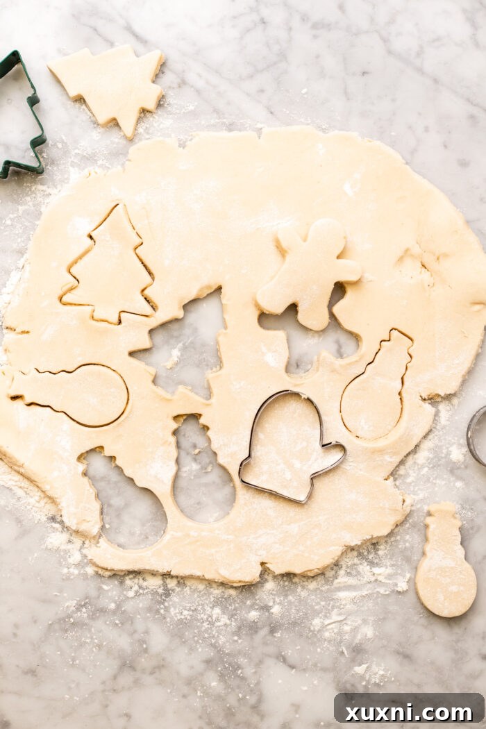 Soft Baked Frosted Dairy-Free Sugar Cookies with Vegan Cream Cheese Frosting 9 Various shapes of cut-out vegan sugar cookies on a baking sheet