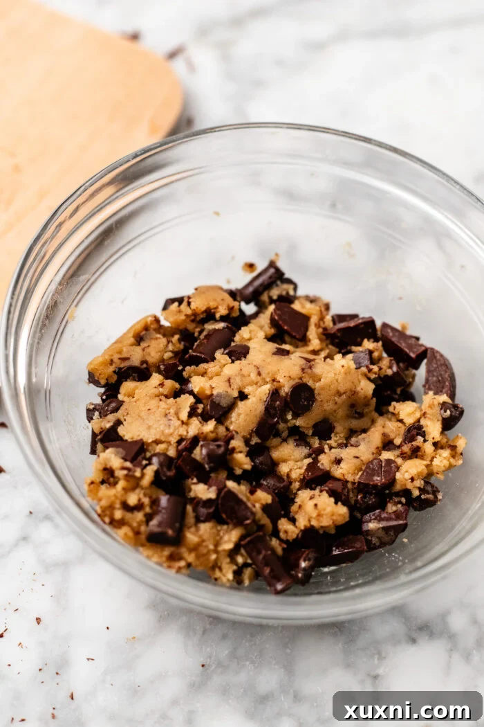Bowl of freshly mixed vegan cookie dough, showing its pliable texture and embedded chocolate chips.