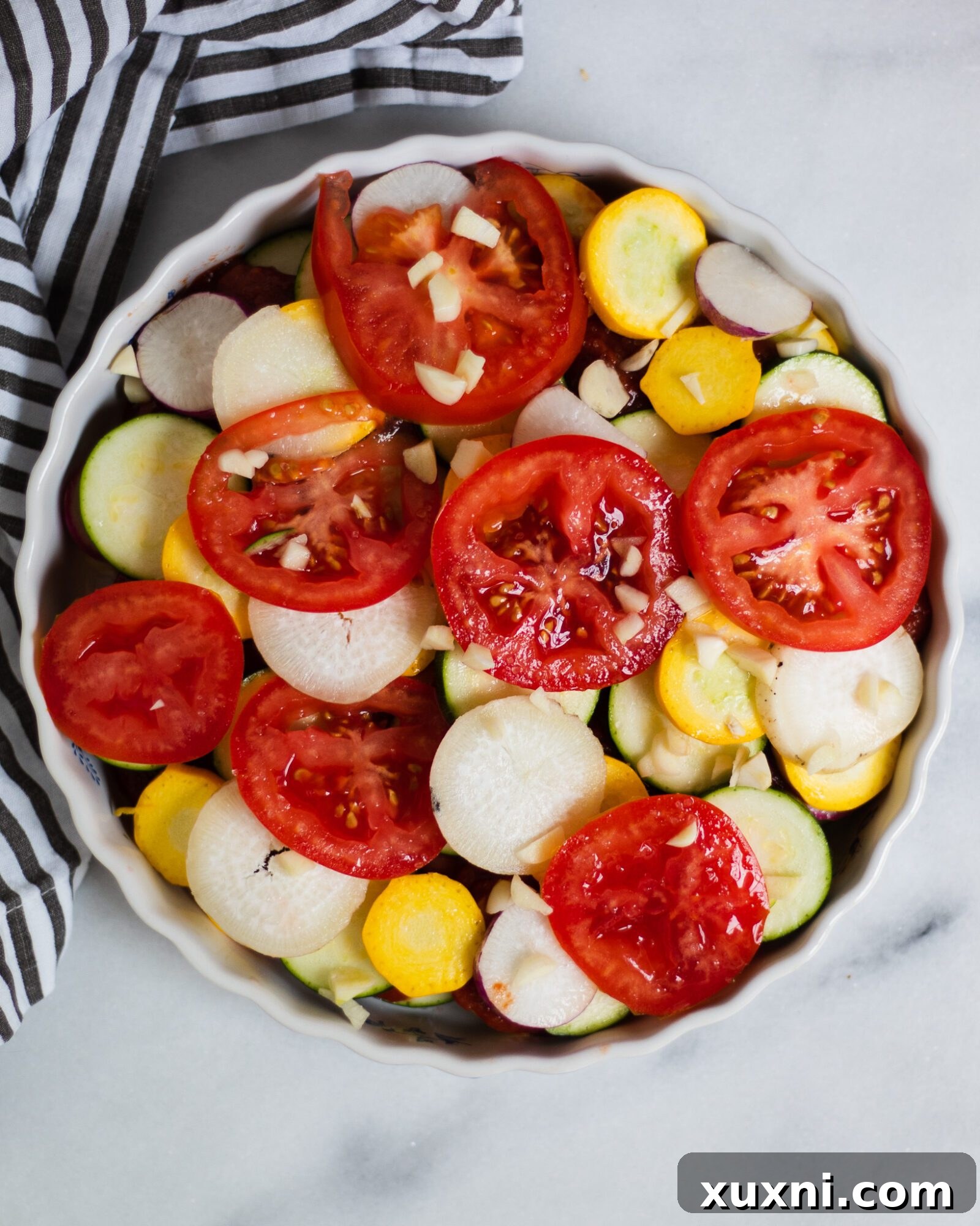 Zucchini and tomatoes layered on top of a delicious ratatouille base