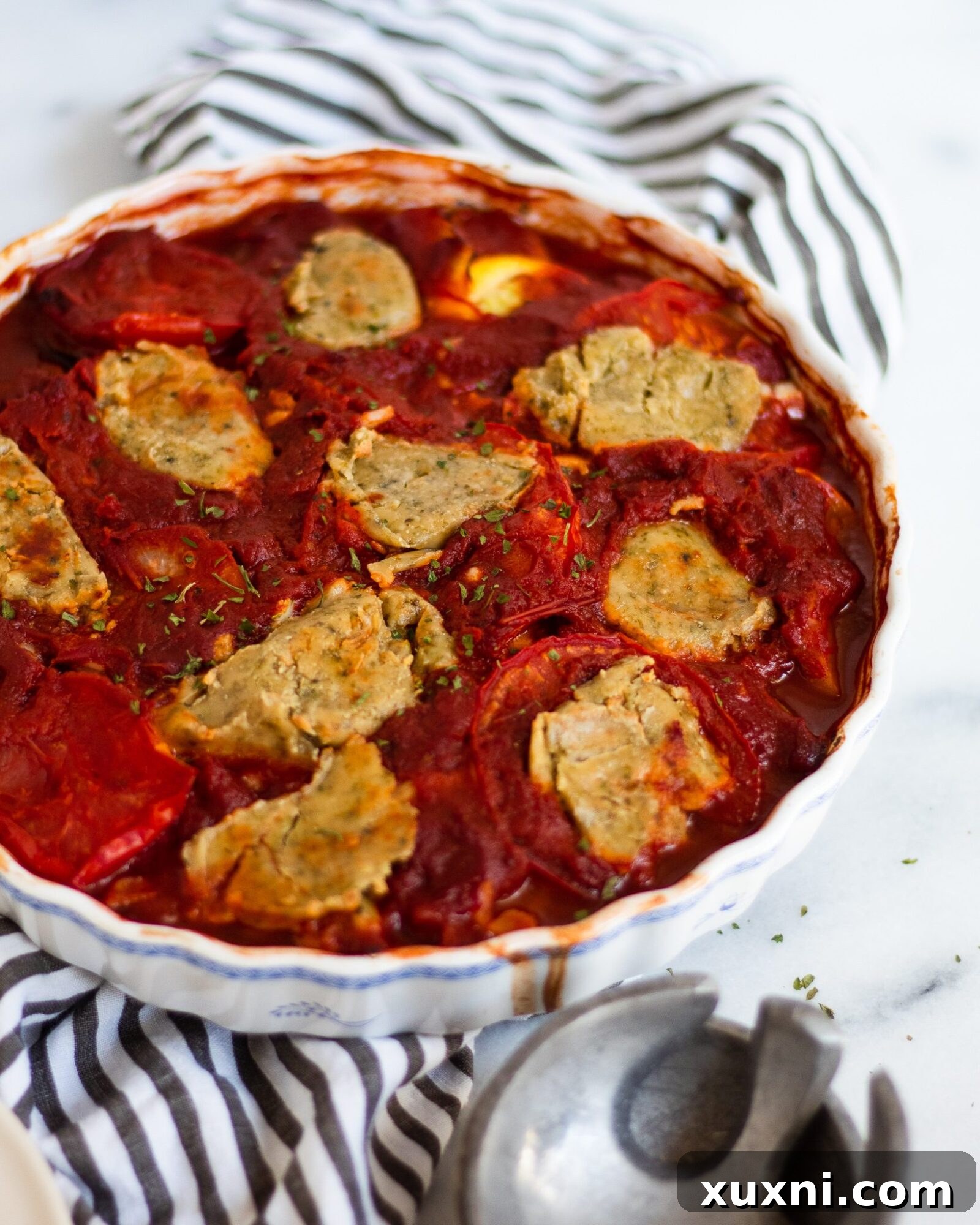 Easy ratatouille served in a baking dish with serving spoons, ready to be enjoyed