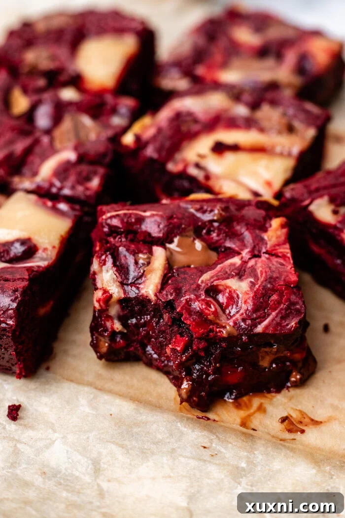 Close-up of a bitten vegan red velvet brownie, showing its moist interior and creamy swirl.