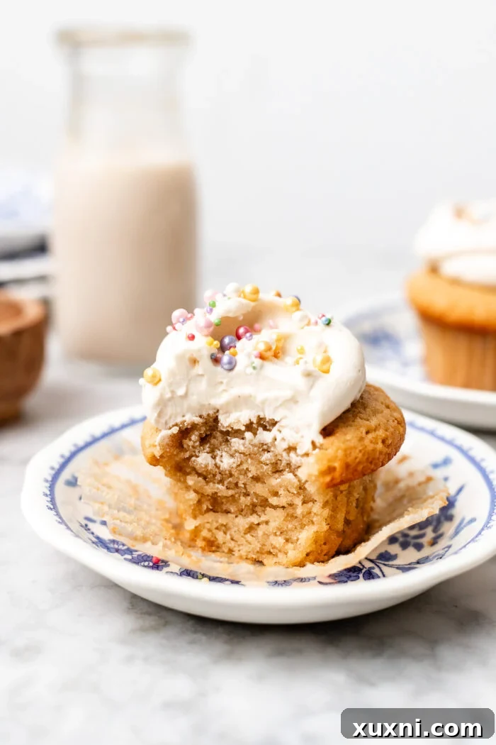 single serve vanilla cupcake on a plate, showcasing its fluffy texture and elegant frosting