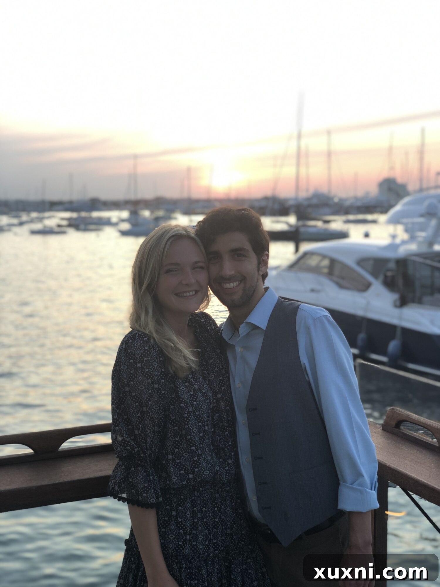 Jared and Britt standing together at sunset, with the sky ablaze with warm colors over the horizon.