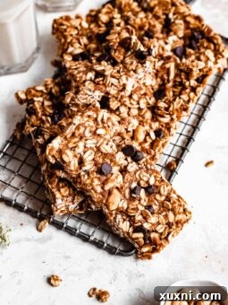Close up of a healthy granola bar on a cooling rack with a pinch bowl of peanuts