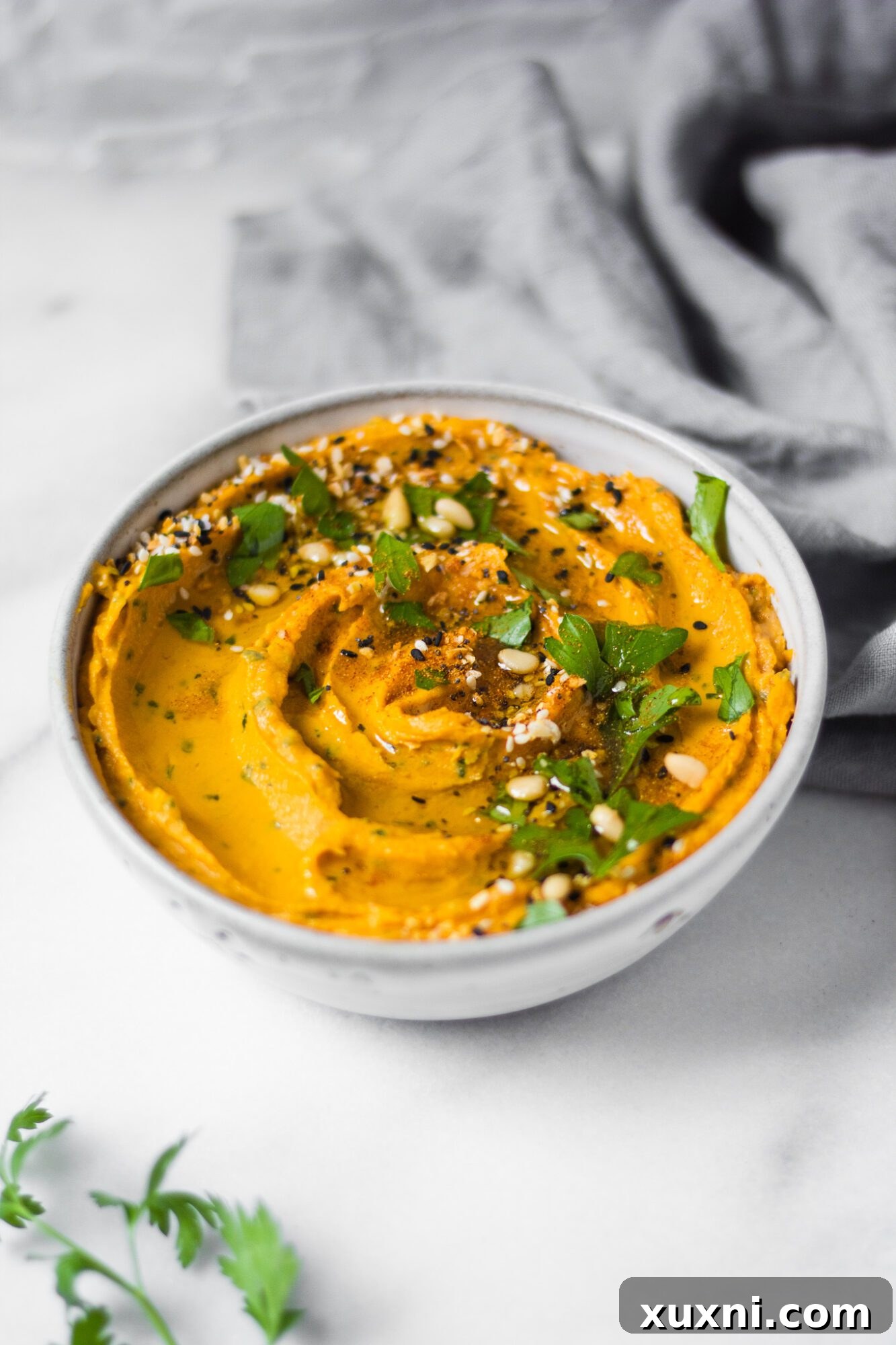 Close-up of healthy sweet potato hummus, showing its creamy texture and rich color.