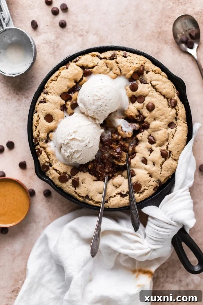 Vegan peanut butter skillet cookie topped with scoops of dairy-free ice cream