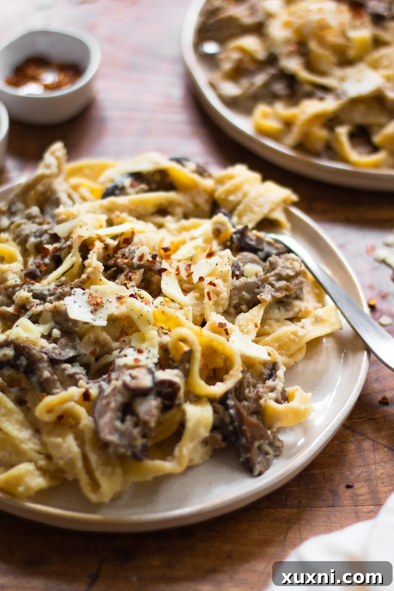Guilt-Free Fettuccine Alfredo 3 Close-up of healthy mushroom pasta featuring fettuccine coated in creamy cauliflower Alfredo sauce and sautéed mushrooms, garnished beautifully.