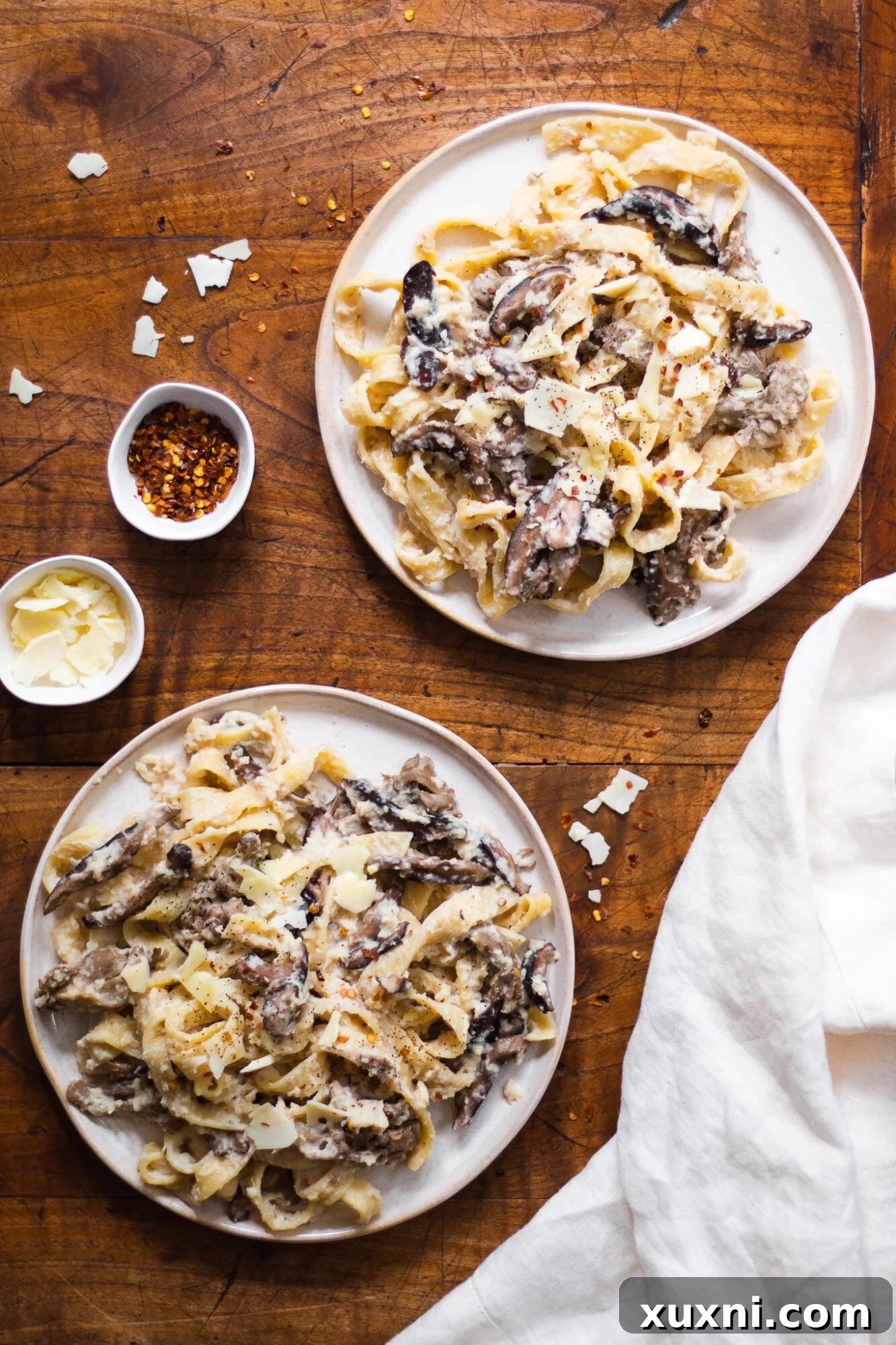 Guilt-Free Fettuccine Alfredo 4 Two plates of healthy fettuccine Alfredo pasta, beautifully plated and ready to serve, highlighting the fresh ingredients and inviting presentation.