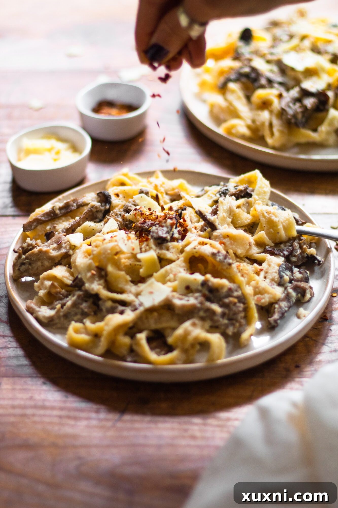Guilt-Free Fettuccine Alfredo 5 A plate of creamy pasta with a sprinkle of red pepper flakes on top, adding a touch of color and subtle heat to the healthy Alfredo dish.