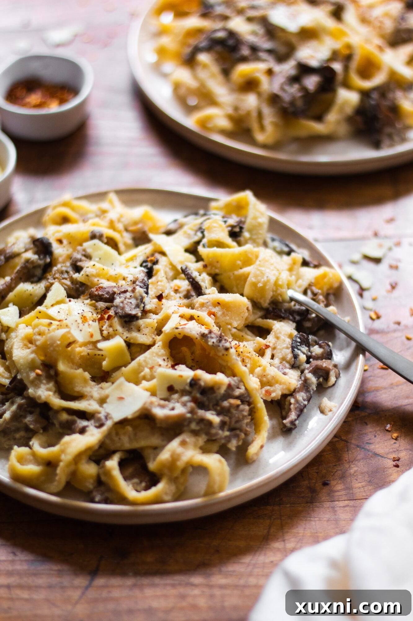 Guilt-Free Fettuccine Alfredo 7 A close-up shot of swirled fettuccine pasta generously coated in healthy Alfredo sauce, showcasing its rich, creamy texture and appealing presentation.