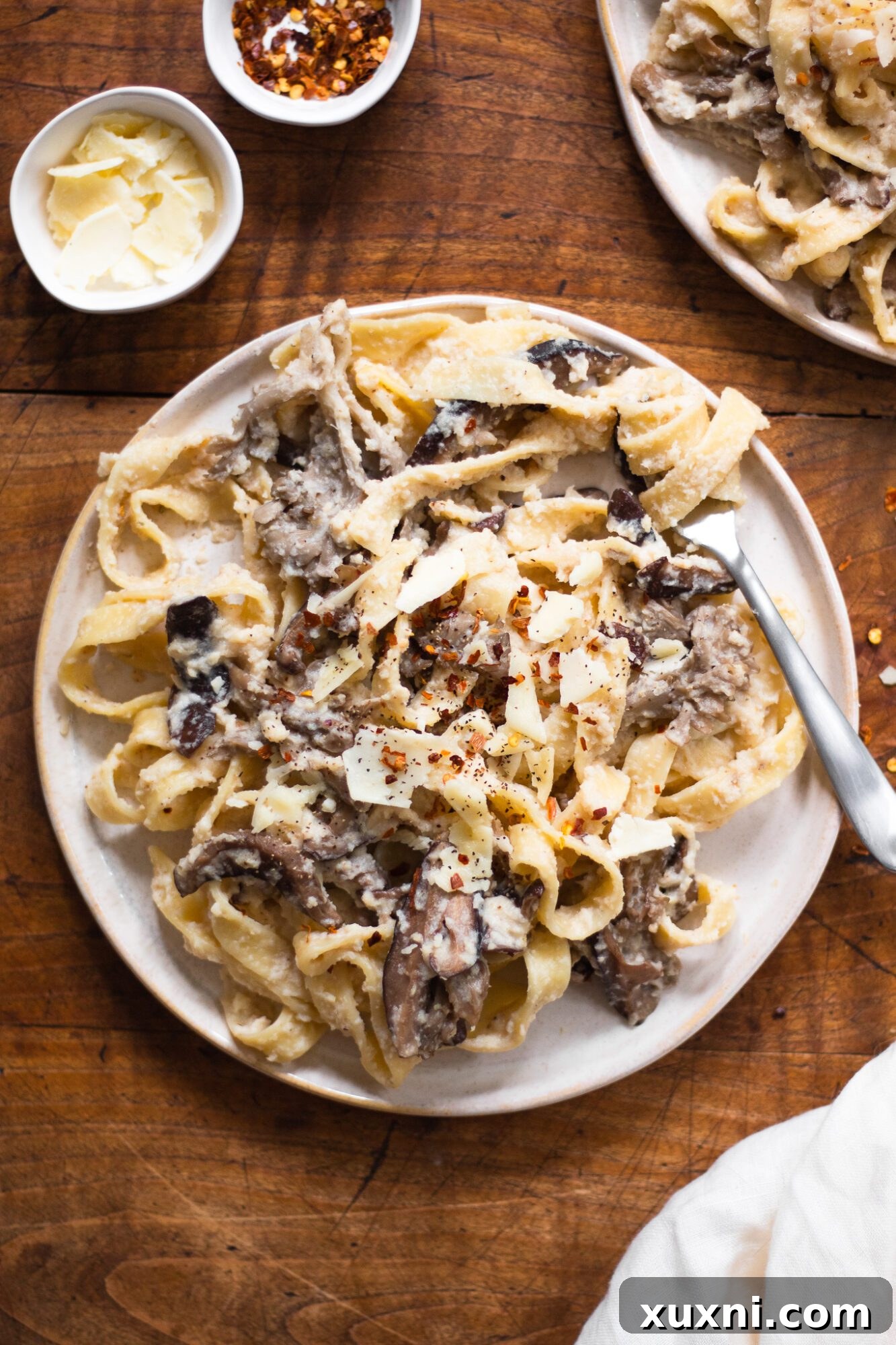Guilt-Free Fettuccine Alfredo 8 A single plate of creamy mushroom pasta, generously coated in healthy Alfredo sauce and topped with sautéed mushrooms and fresh herbs.