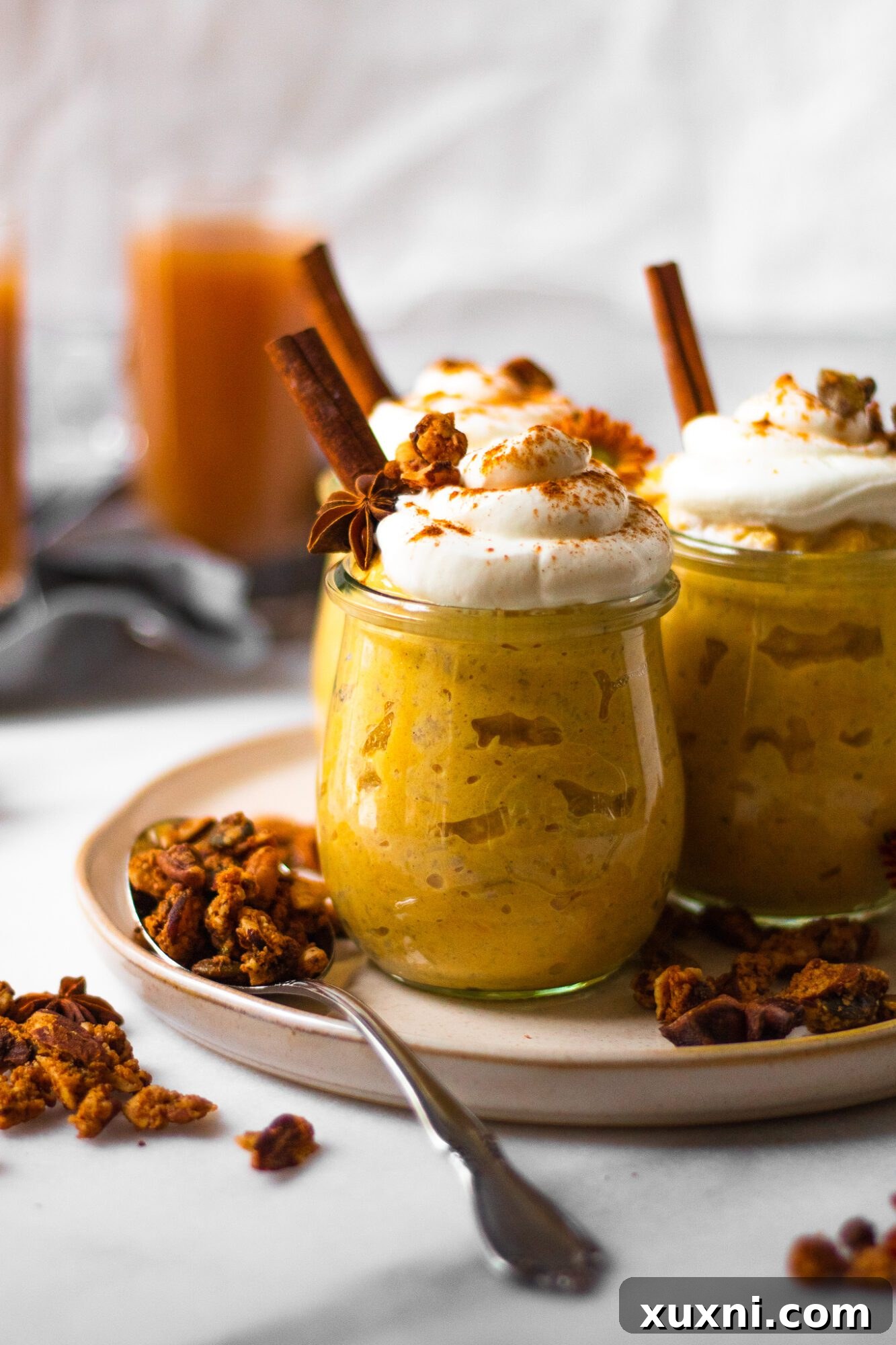 Close-up view of a jar filled with pumpkin pie oatmeal, showing layers of creamy oatmeal and delicious toppings