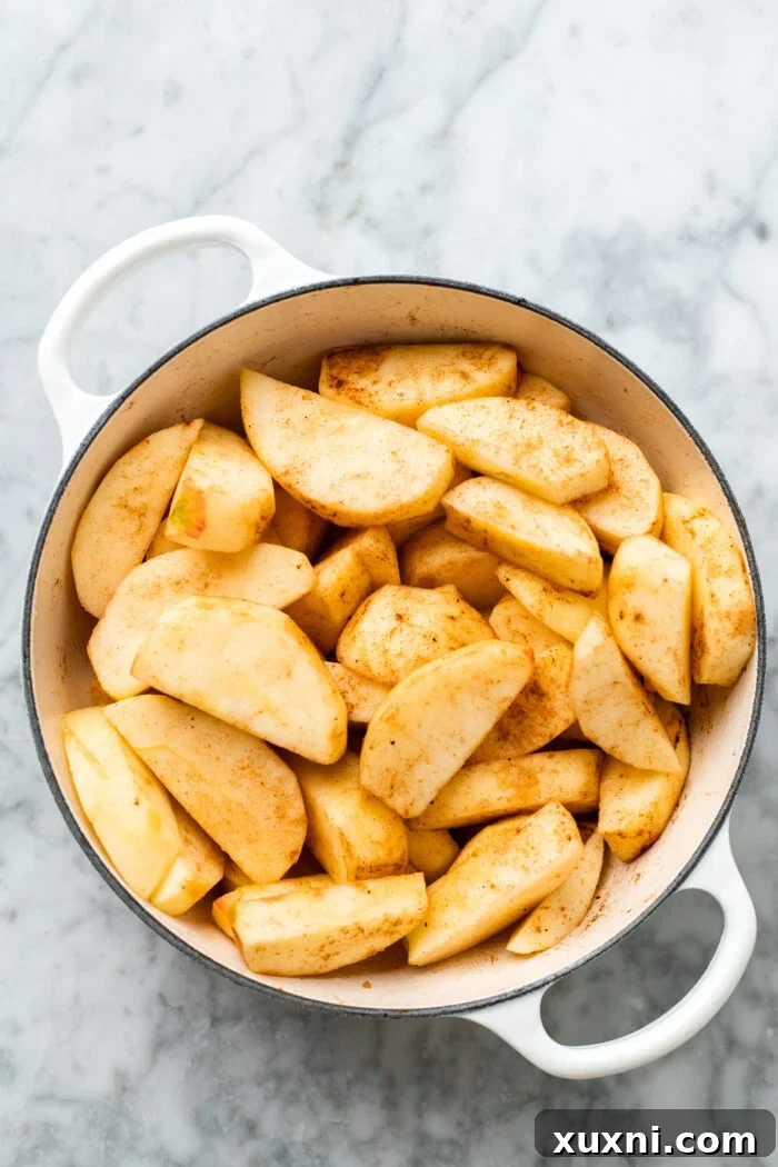 Quick Vegan Apple Crisp Naturally Sweetened 7 Sliced apples mixed with lemon juice and cinnamon in a bowl, ready for the crisp base.
