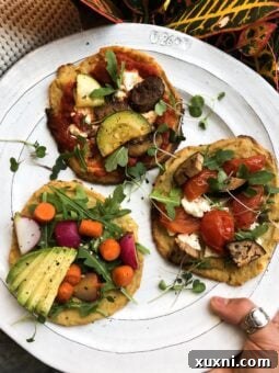 Crispy vegan cauliflower pizza crust topped with fresh basil and cherry tomatoes.
