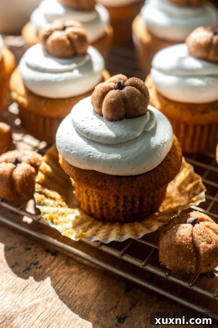 Close-up of a vegan pumpkin cupcake with its liner removed, showcasing its perfect shape.