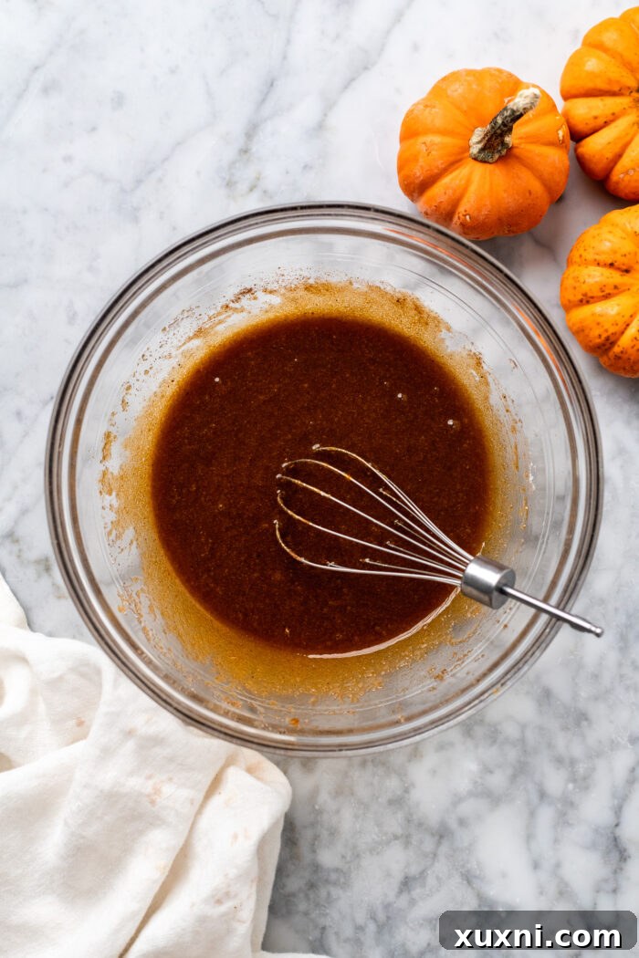 Wet ingredients being whisked in a bowl for the pumpkin cupcakes.