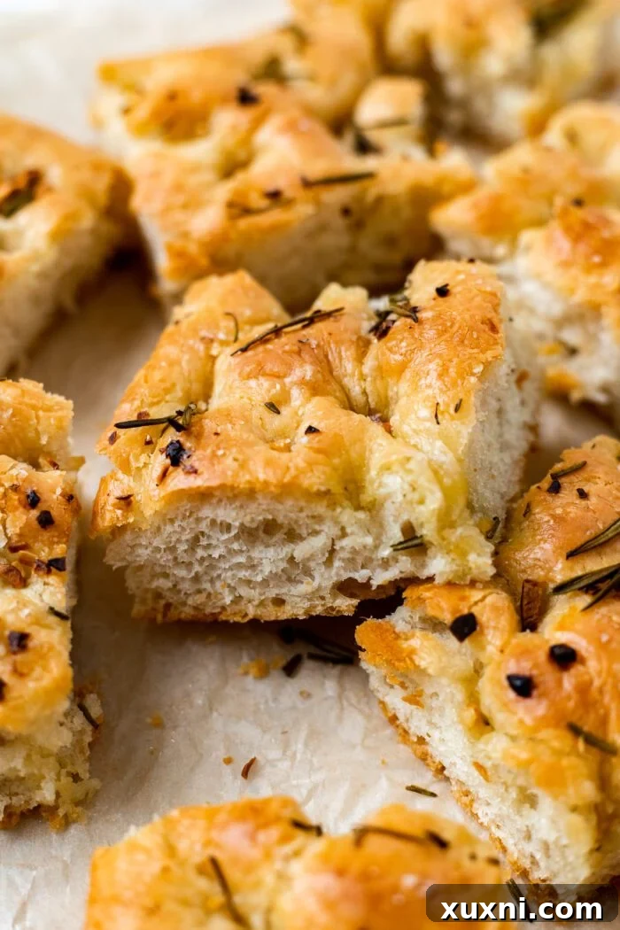 sliced vegan focaccia with garlic rosemary oil on parchment