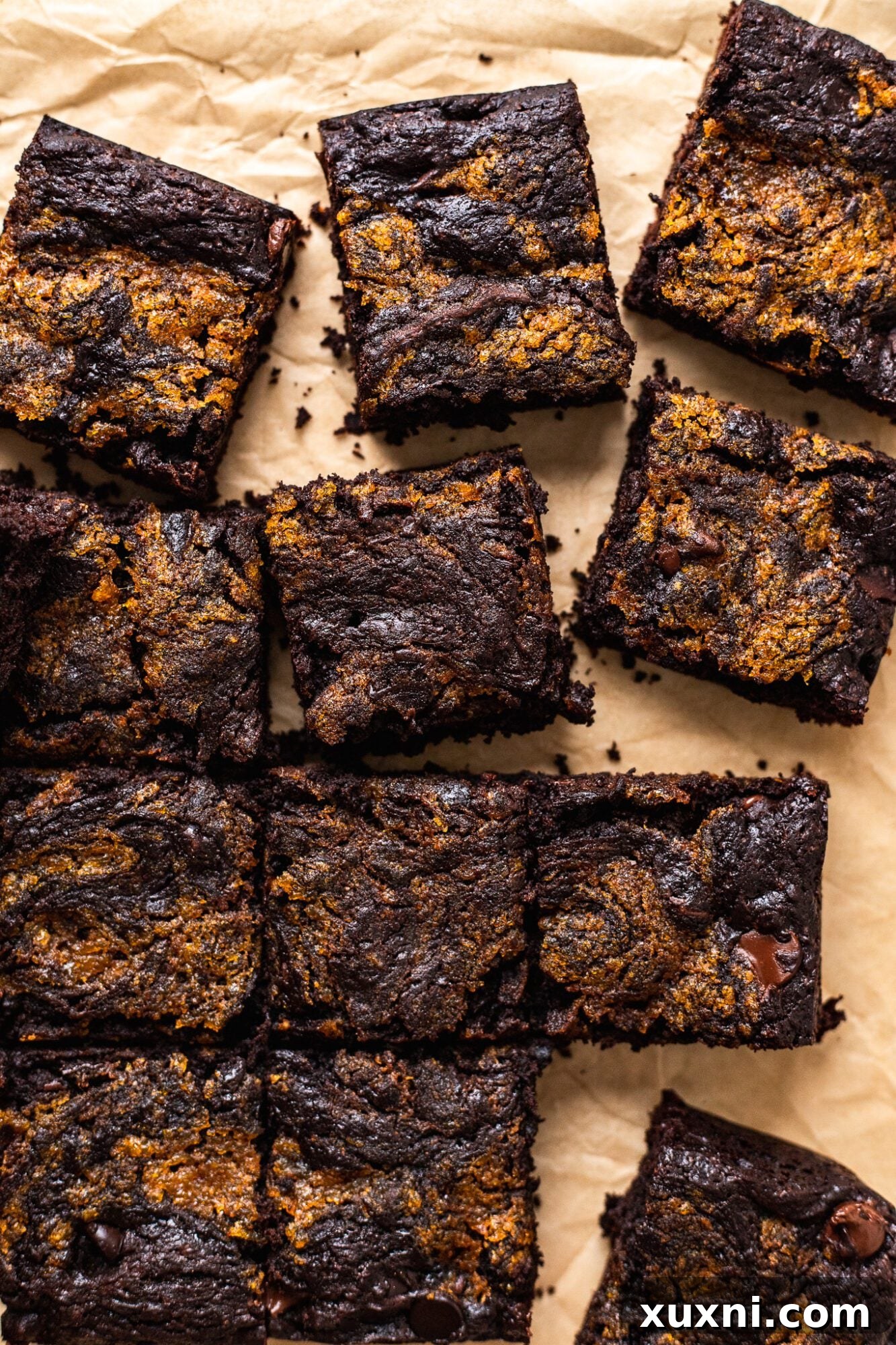 Close-up of a square pan filled with vegan pumpkin swirl brownies, showing the rich chocolate and creamy pumpkin layers.