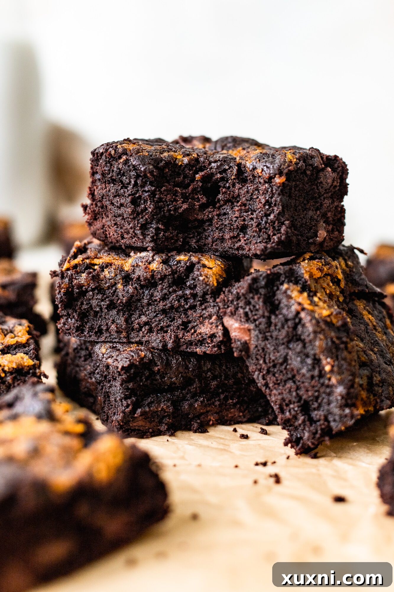 Stack of freshly baked vegan pumpkin brownies with visible swirl, ready to be enjoyed.
