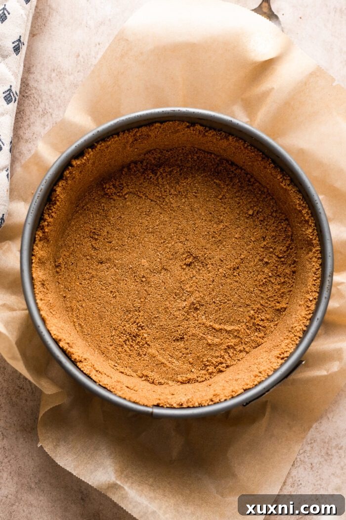 Close-up of the perfectly pressed vegan graham cracker crust in a springform pan.