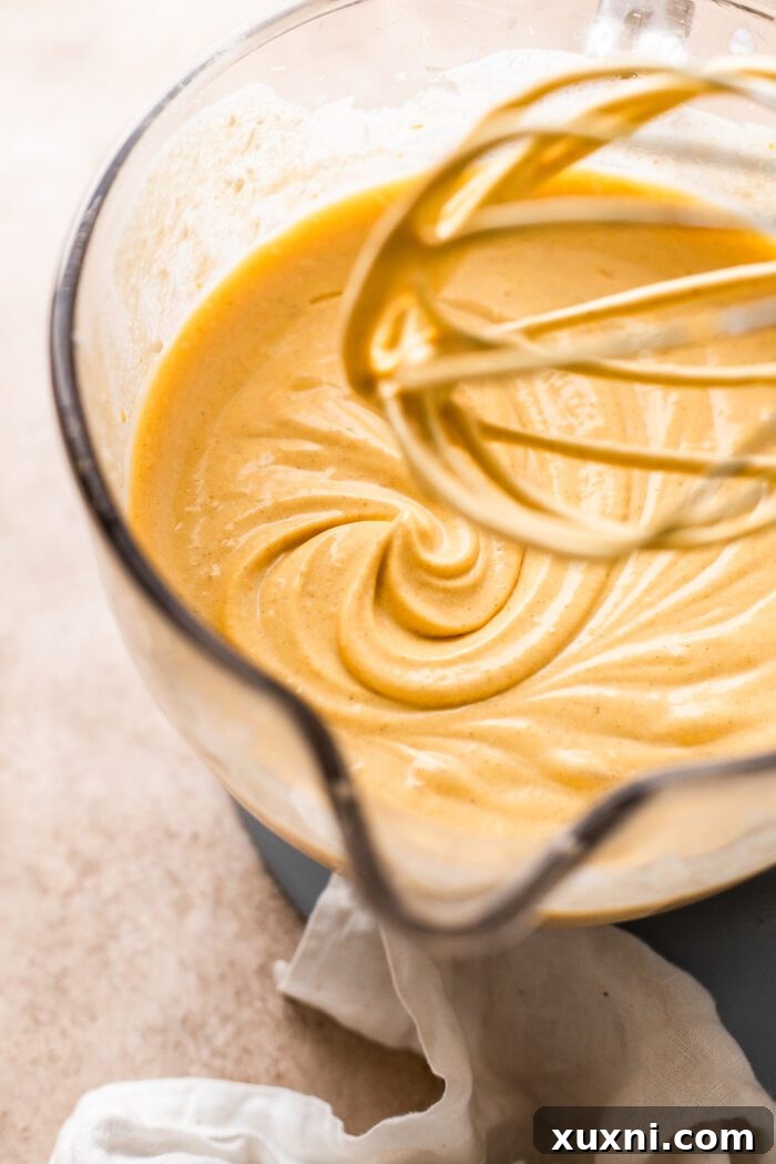 Rich and creamy vegan pumpkin cheesecake filling in a mixing bowl, ready for assembly.