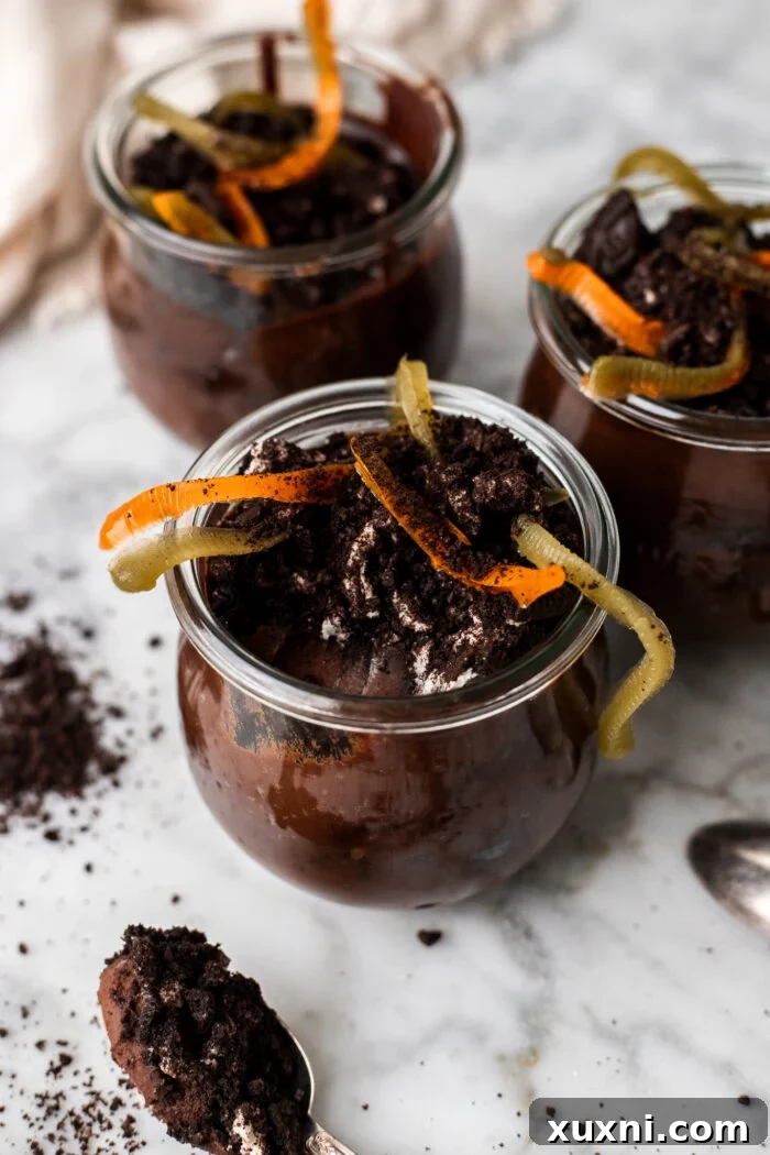 Delicious cups of vegan dirt pudding with gummy worms, perfect for Halloween.